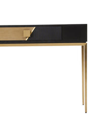 Close-up of the gold-finish handle on the fluted black drawer front