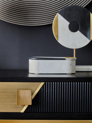 Fluted console table styled with a lamp and decorative tray in a hallway