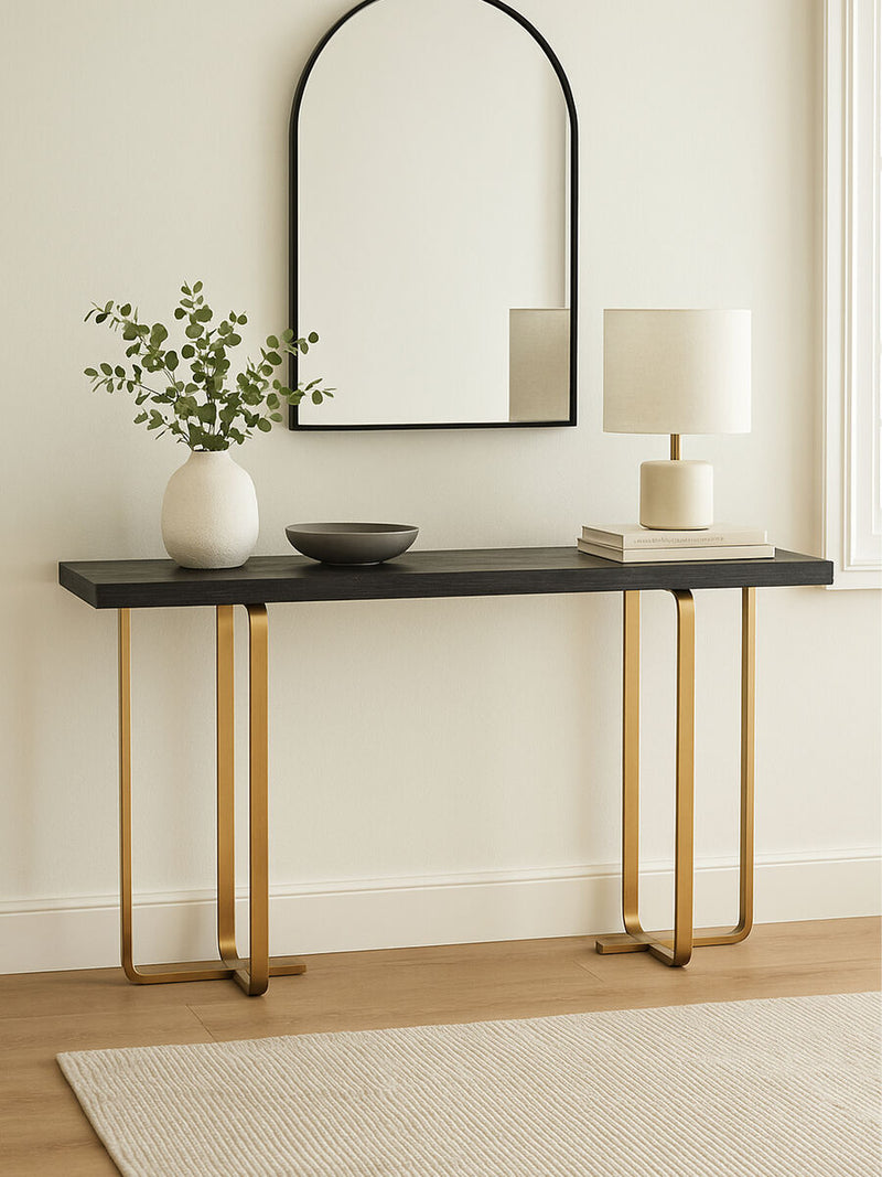 Console table styled in a living room setting with a lamp and decorative tray on the black and grey top