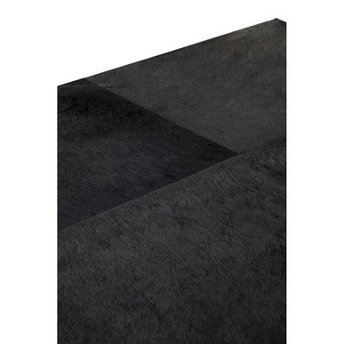 Macro close-up of the black hair-on-hide leather texture on the tabletop