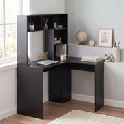 Black corner desk with laptop beside a window and wall decor