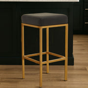 Black leather effect bar stool with gold finish base at a kitchen counter