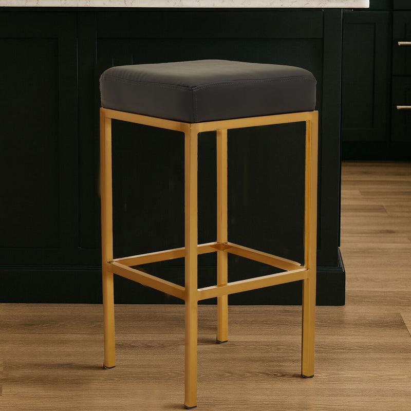 Black leather effect bar stool with gold finish base at a kitchen counter