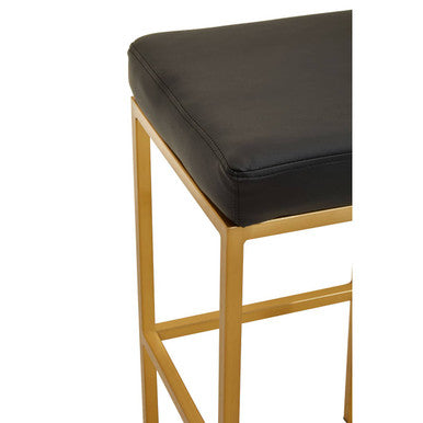 Close-up of black leather effect seat on gold base bar stool