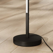 Close-up of the round weighted base and cable of the floor lamp
