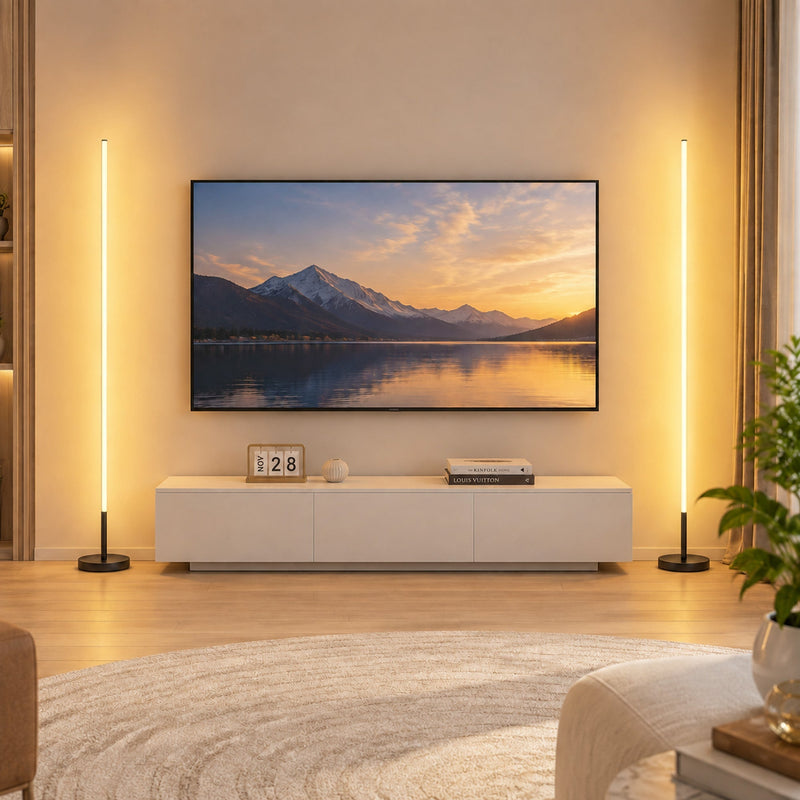 Two lit floor lamps either side of a TV unit in a living room