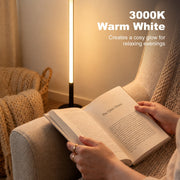 Warm white lamp glowing beside a person reading a book on an armchair
