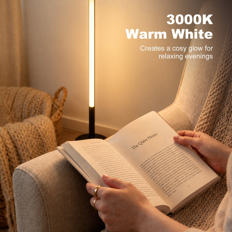 Warm white lamp glowing beside a person reading a book on an armchair