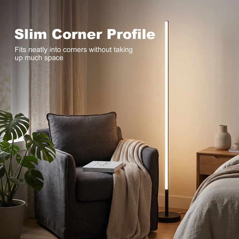 Slim floor lamp in a bedroom corner beside an armchair and bedside table