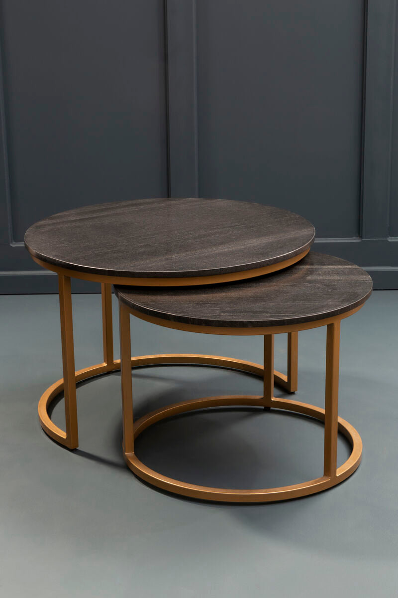 Nesting marble coffee tables in a living room setting with the smaller table pulled out beside an armchair