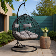 Black rattan double hanging chair styled in a living room setting
