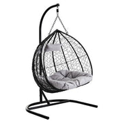 Black rattan double hanging chair with grey cushions, plain background