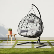Black rattan double hanging chair styled in a living room setting