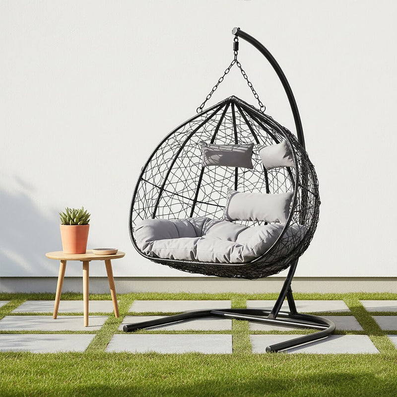 Black rattan double hanging chair styled in a living room setting