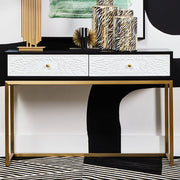 Black and white two drawer console table with gold sledge base in a styled hallway