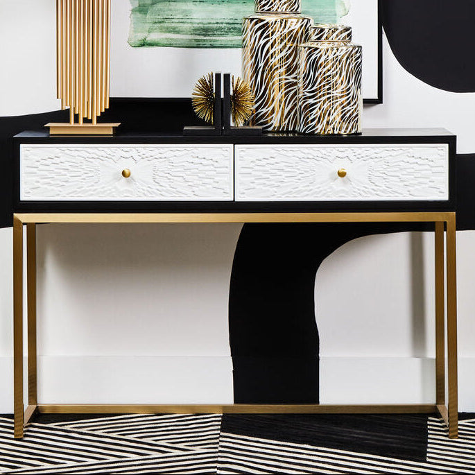 Black and white two drawer console table with gold sledge base in a styled hallway