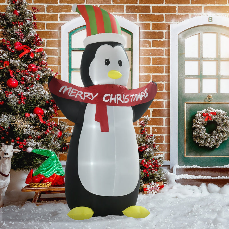 Inflatable penguin by a front door with a Christmas tree and wreath