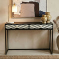 Black and white bone inlay chevron console table styled in a hallway with a mirror above