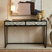 Black and white bone inlay chevron console table styled in a hallway with a mirror above