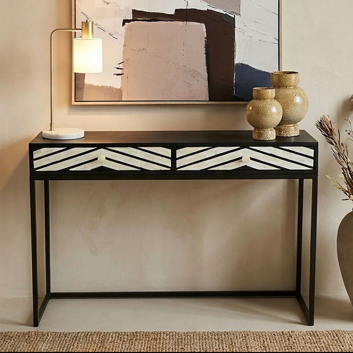 Black and white bone inlay chevron console table styled in a hallway with a mirror above