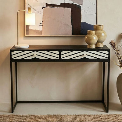 Black and white bone inlay chevron console table styled in a hallway with a mirror above