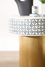 Bone inlay side table styled with books and a vase in a lounge corner