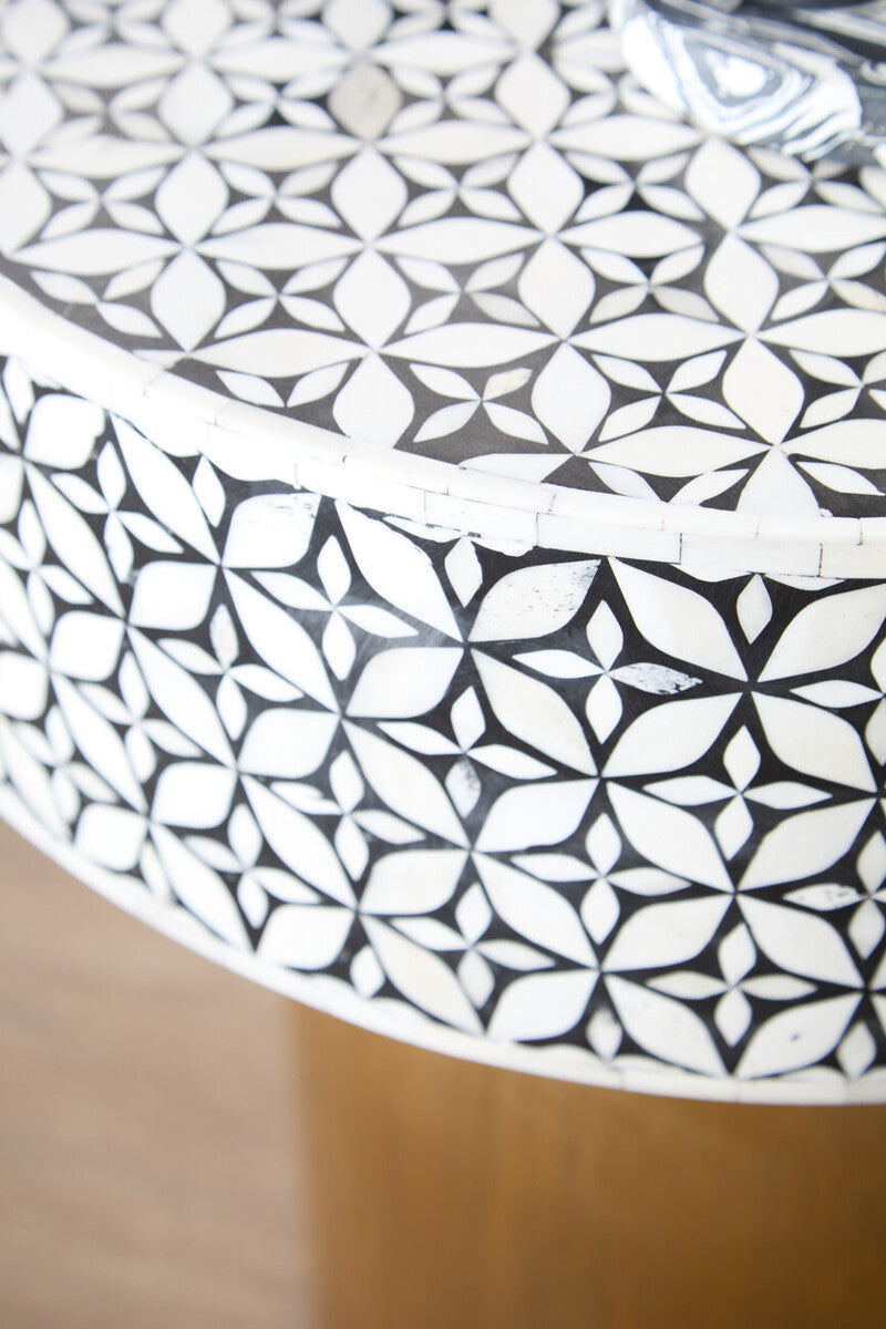 Bone inlay round side table in a styled interior beside an armchair