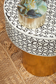 Round side table in a living room setting next to a neutral sofa