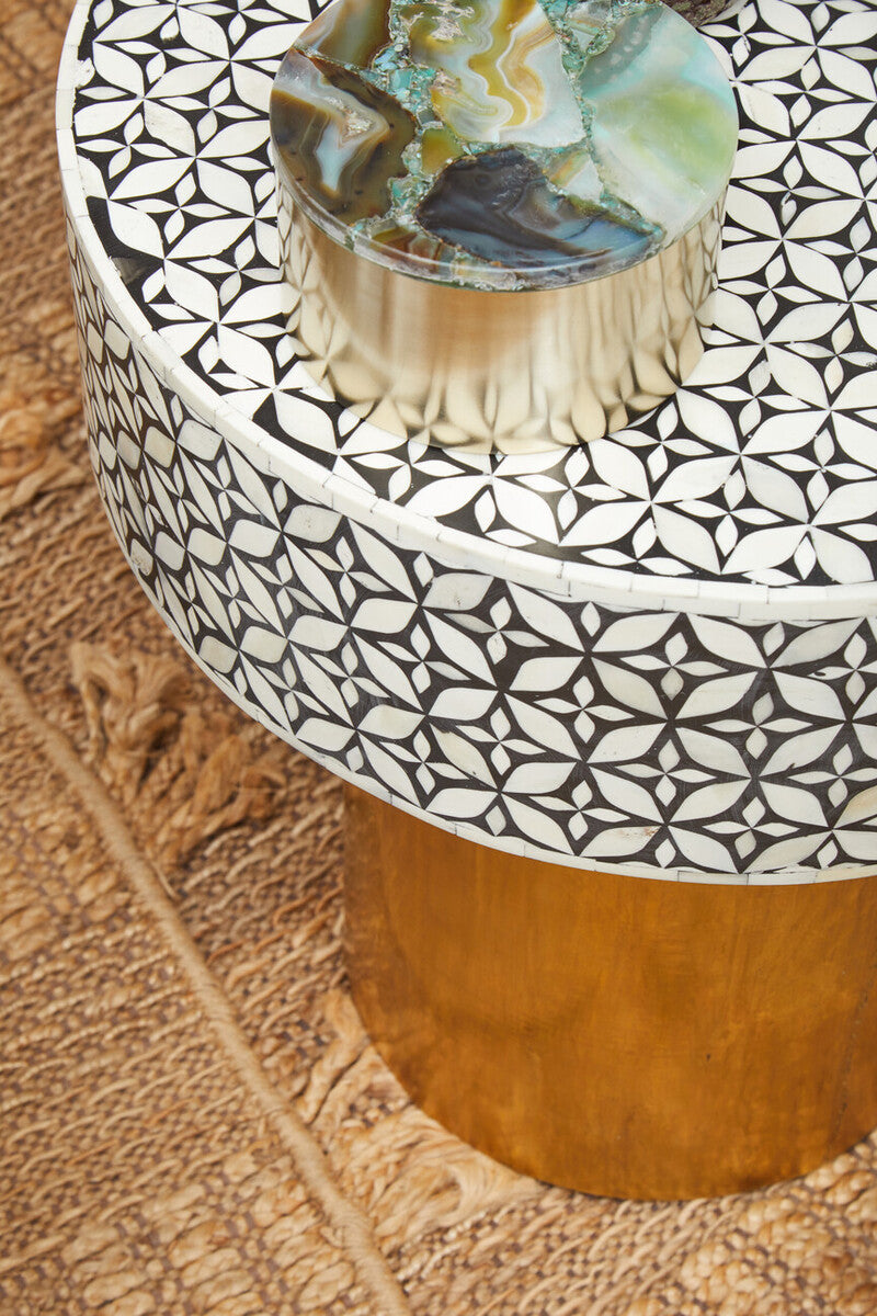 Round side table in a living room setting next to a neutral sofa