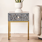 Black bone inlay side table with gold legs styled in a living room setting