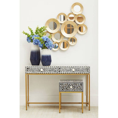 Bone inlay side table used as a bedside table beside a bed