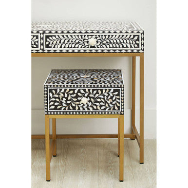 Black bone inlay side table styled beside an armchair with a table lamp