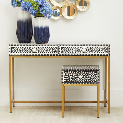 Black and white floral bone inlay console table with gold legs styled in a hallway