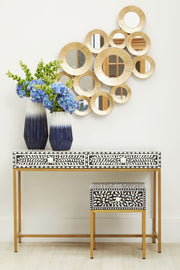 Floral bone inlay console table in an entrance hall beneath a round mirror