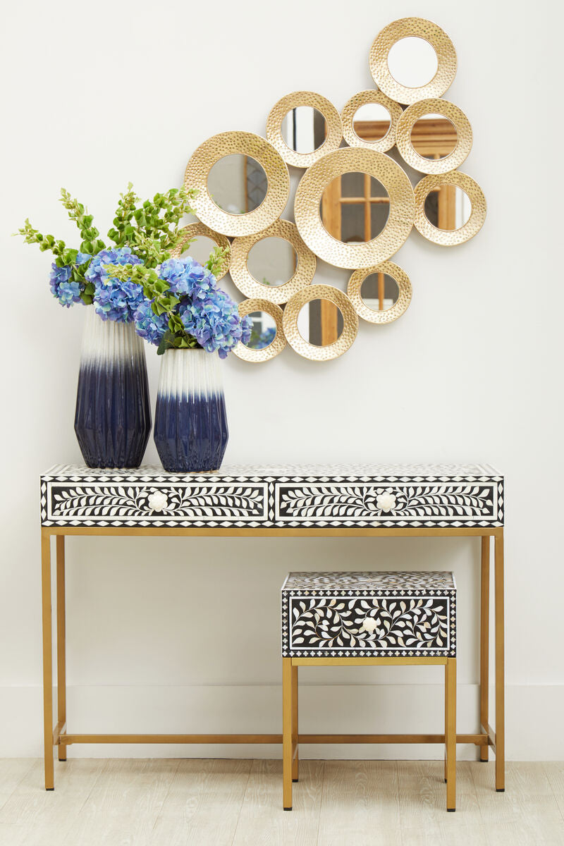 Floral bone inlay console table in an entrance hall beneath a round mirror