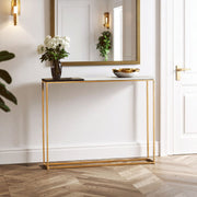 Black and white marble console table with gold frame styled in a hallway