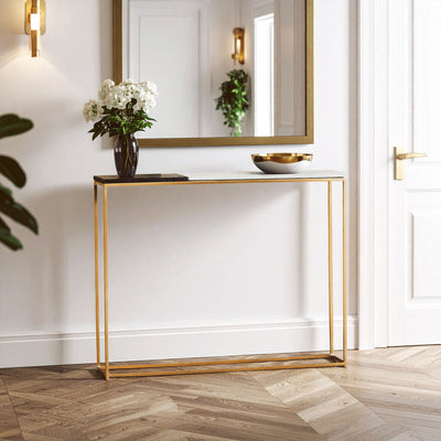 Black and white marble console table with gold frame styled in a hallway