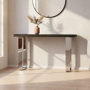 Black wood and clear glass console table with silver U-shaped legs styled in a modern hallway