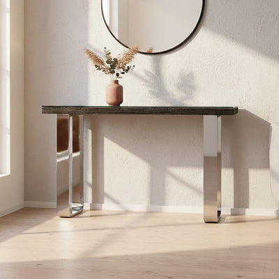Black wood and clear glass console table with silver U-shaped legs styled in a modern hallway