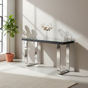 Black glass topped console table placed behind a sofa in an open-plan room