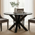 Black wood veneer round dining table styled in a dining room with upholstered chairs