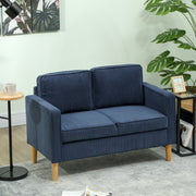 Blue corduroy sofa in a green-toned living room with a side table