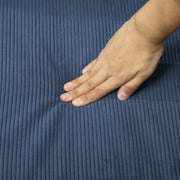 Close-up of a hand pressing into the corduroy seat cushion