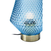 Close-up of gold ring base on blue glass table lamp
