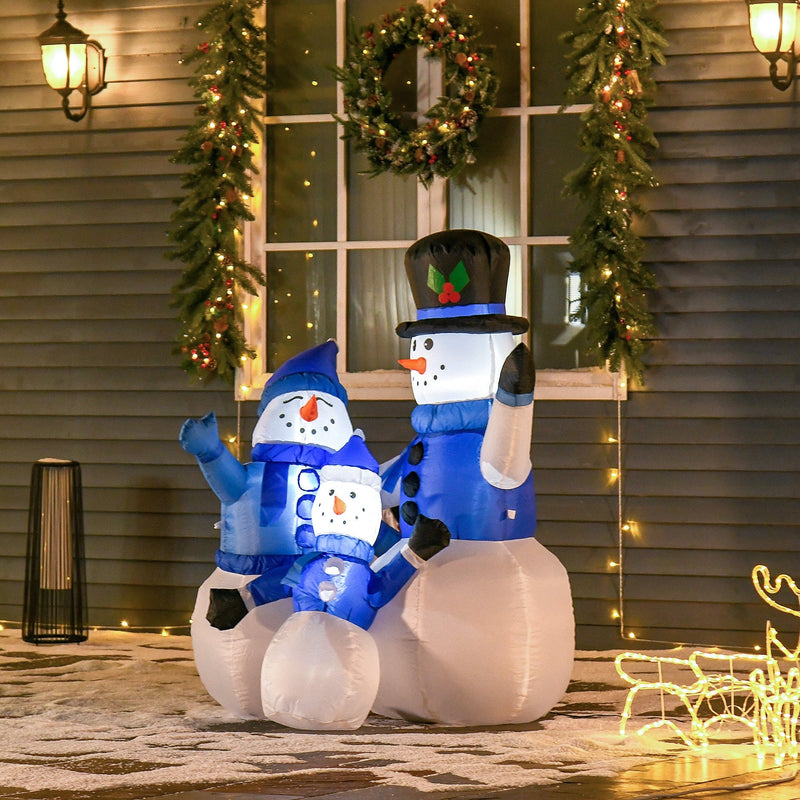 Inflatable snowman family beside a porch window with a Christmas wreath and lights