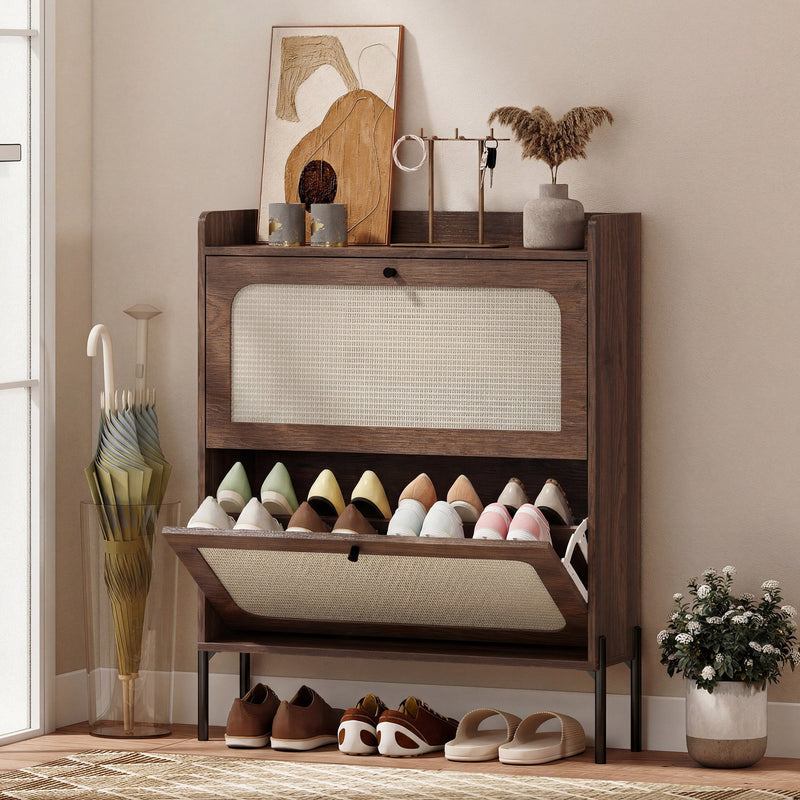 Dark brown rattan shoe cabinet in a hallway with shoes in the open lower drawer