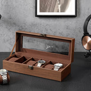 Watch box on a dark desk with one cushion lifted out and a watch beside it