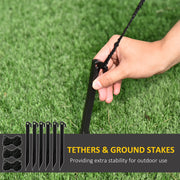 Hand pushing a ground stake into grass beside the tethers and 6 ground stakes