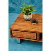 Brown acacia wood coffee table styled with decor in a living room