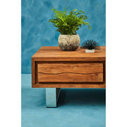 Brown acacia wood coffee table styled in a lounge setting